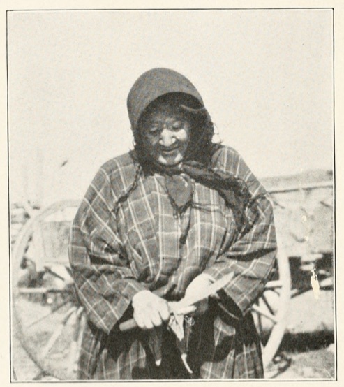 Native American woman in headscarf working with knife