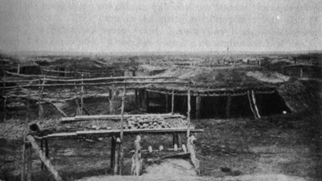 wooden-framed structures, one partially covered by earth