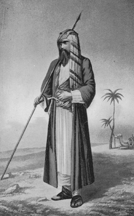 Burton dressed in long robes and headress holding a staff with two palm trees and a camel in the background.