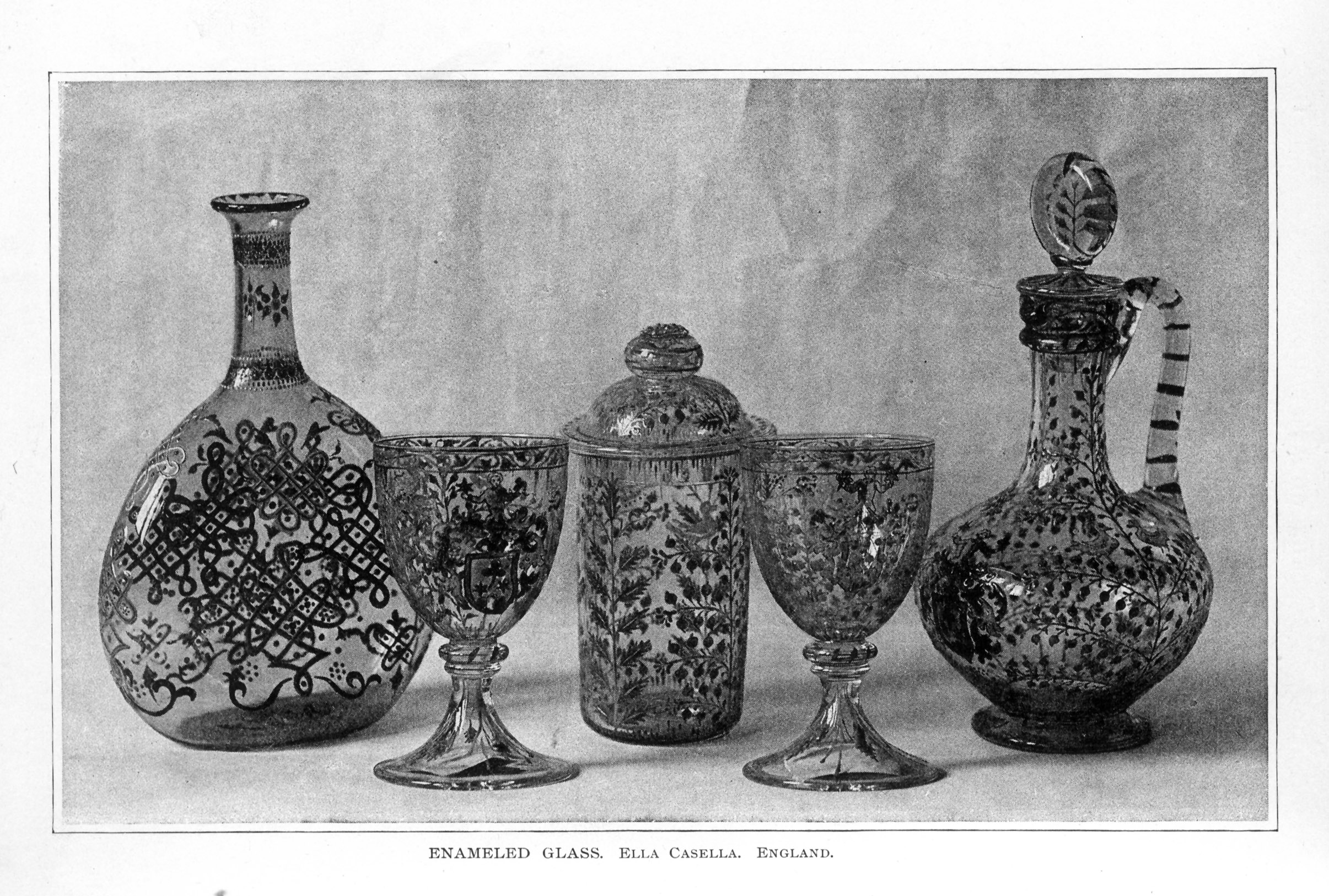 glass vase, jar, chalices, and decanter, all decorated with scrollwork