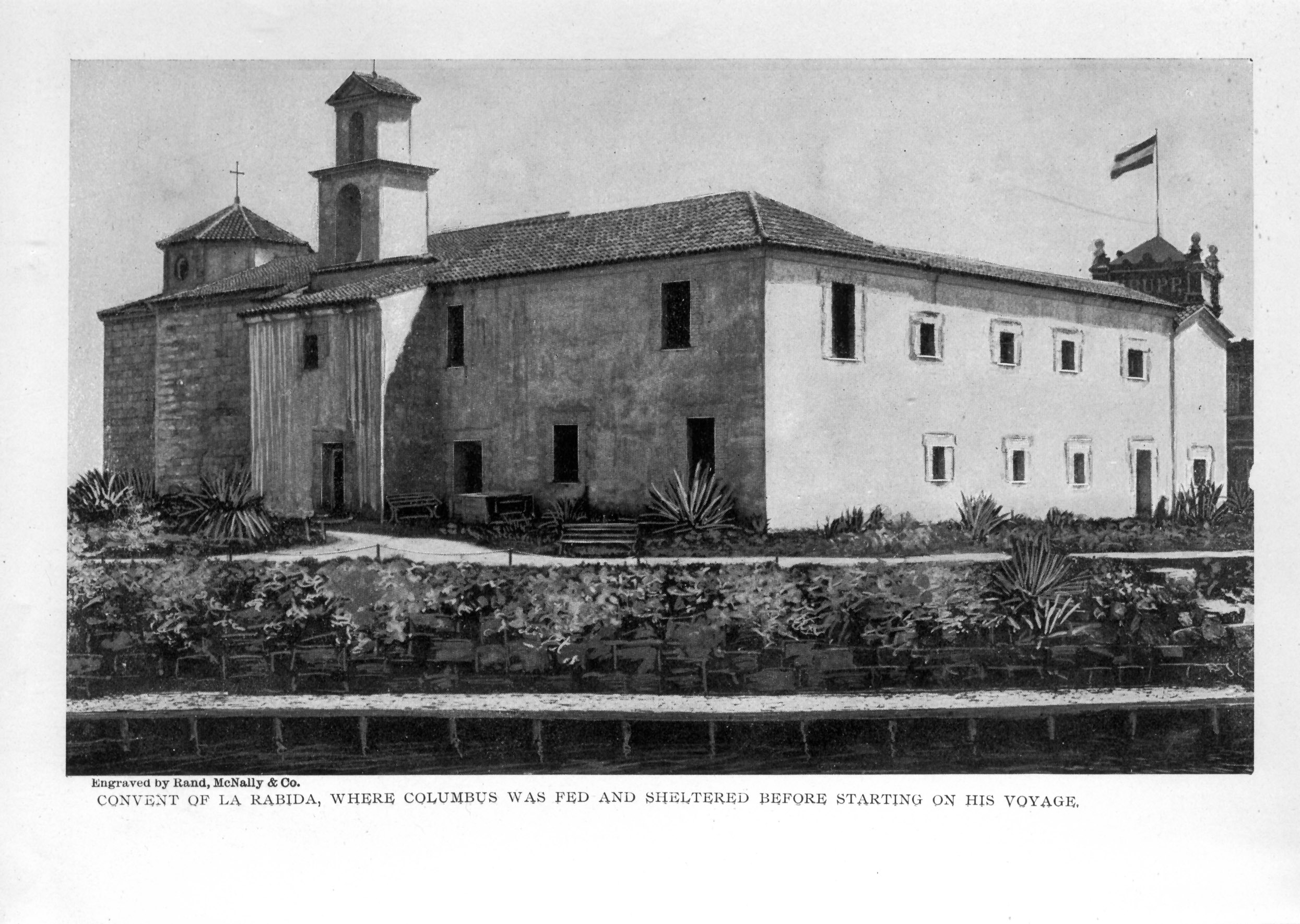 plain two story building with cross decoration and flag on roof