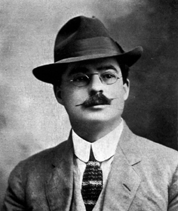 photograph of man with mustache, hat, and glasses