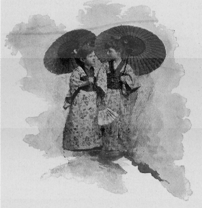 Two girls wearing kimonos and carrying paper parasols.