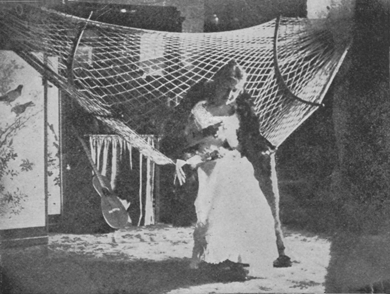 Woman sitting in rope hammock.