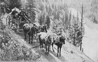 two people in a carriage drawn by four horses