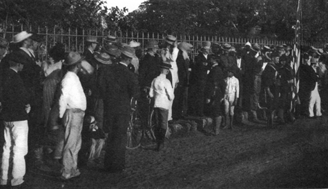 men lined up along a fence