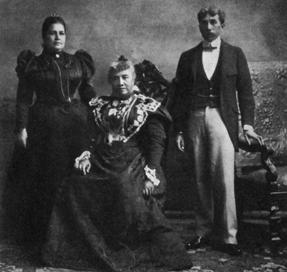 seated woman with medals on her dress flanked by man and woman standing